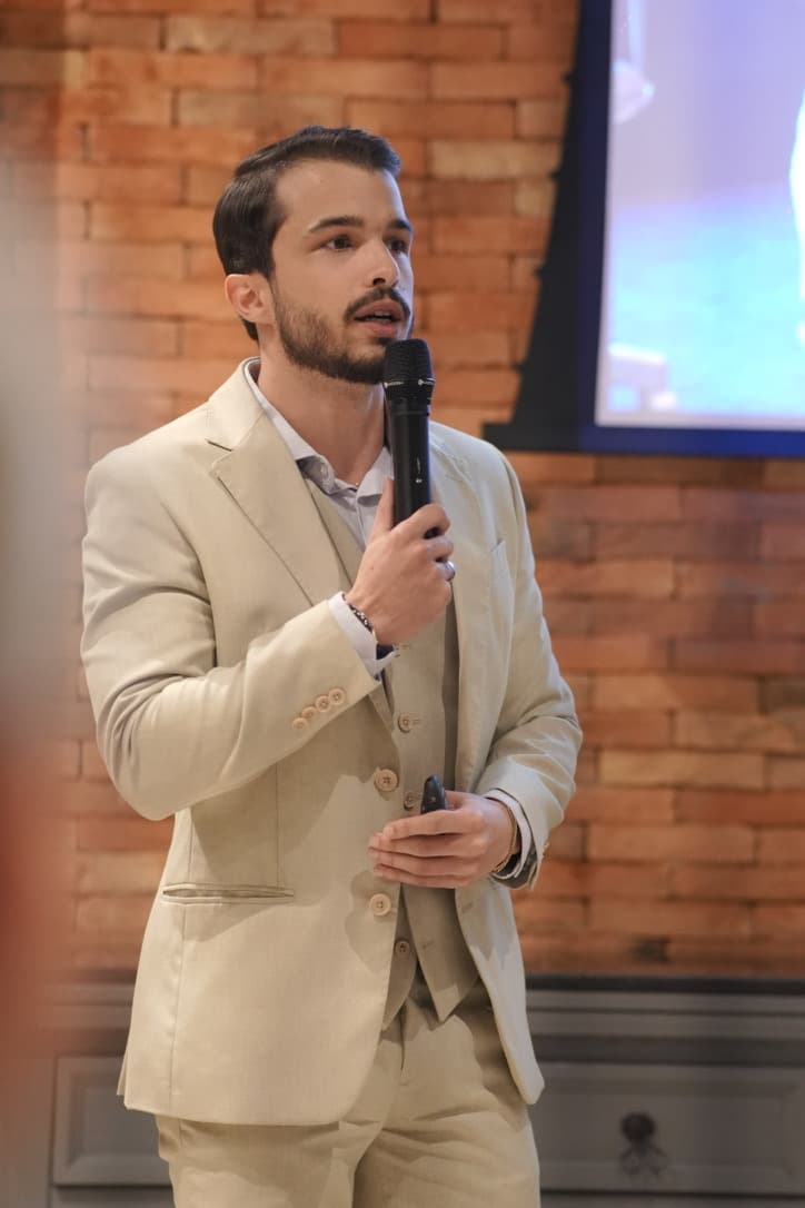 Wigor Cadore discursando com microfone durante uma apresentação